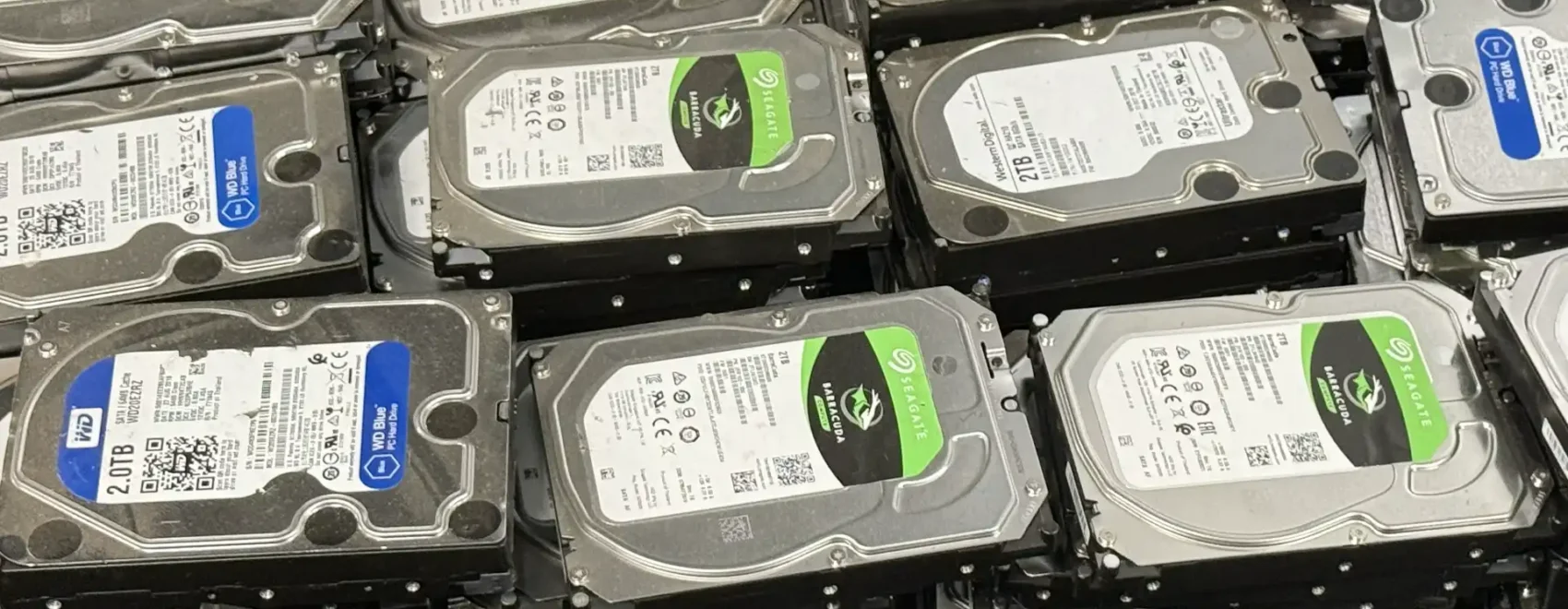 Stack of multiple 3.5-inch hard drives in a rack, showing Seagate and WD labels (2 TB to 4 TB).